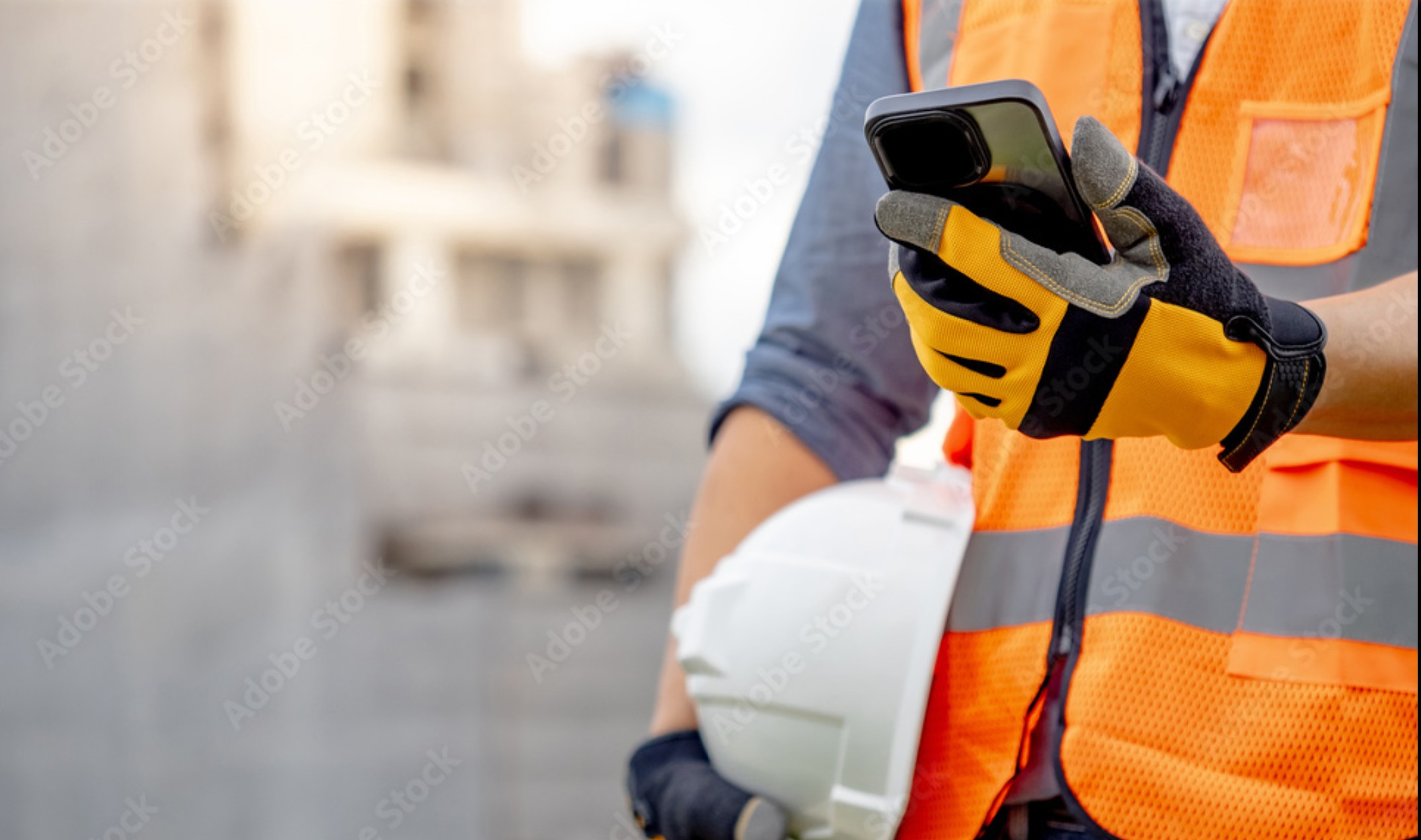 Construction worker using Hedge app on smartphone at jobsite